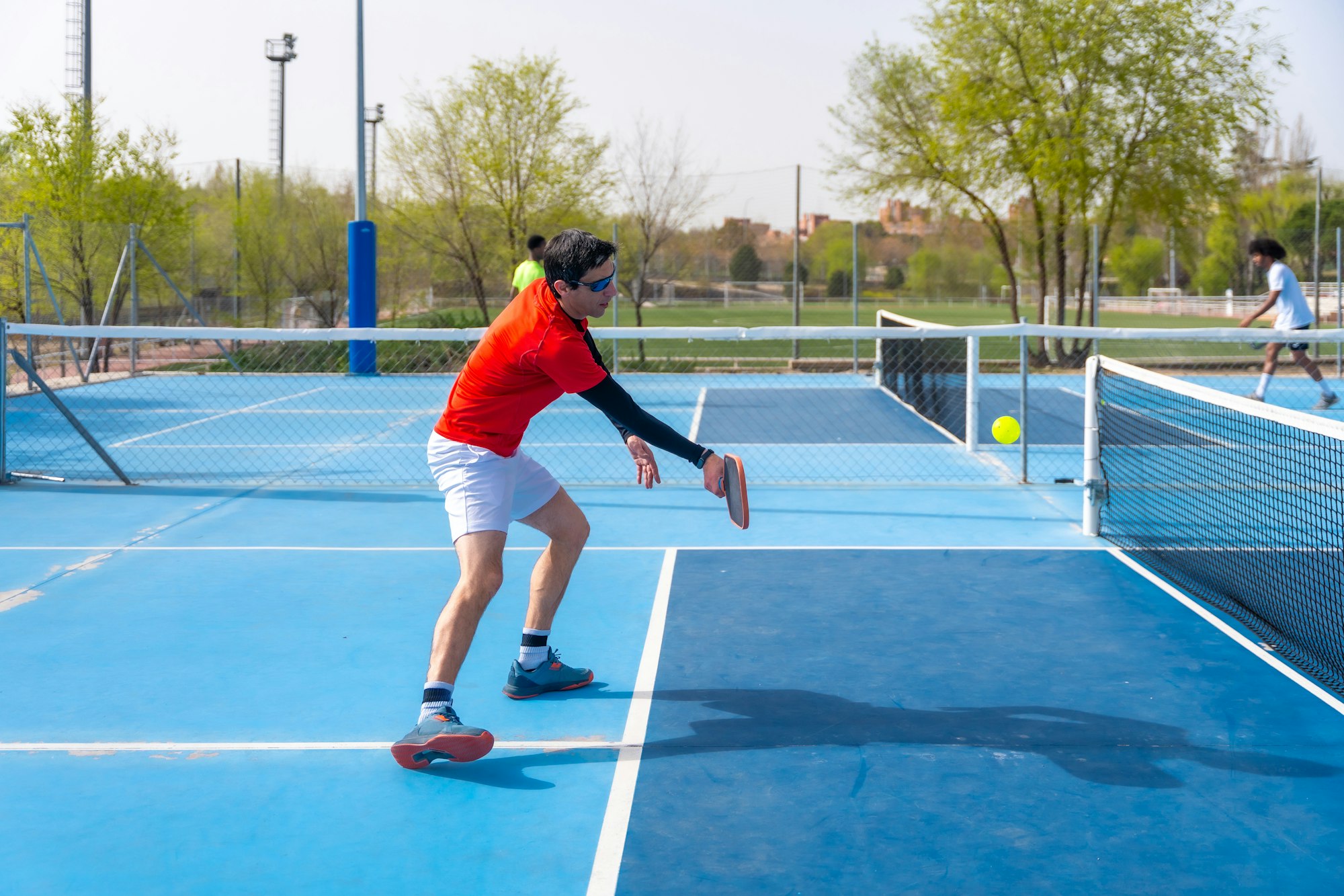 Man in sportive clothes playing pickleball outdoors